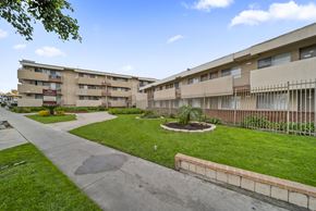 North Hollywood apartment for rent - A concrete pathway leads to a grassy area in front of apartment buildings.