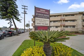 North Hollywood apartment for rent - A palm tree stands in front of a sign for Academy Pointe Apartments.