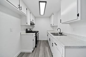 Wilmington apartment for rent - A kitchen with white cabinets and a black stove top oven.