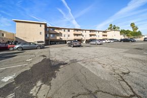 Van Nuys apartment for rent - A parking lot with a building in the background and several cars parked.