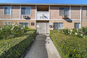 N. Hollywood apartment for rent - The image shows a building with the number 6107 on it, surrounded by a neatly trimmed hedge and a clear blue sky.