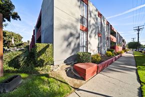 North Hills apartment for rent - A long building with red trim and a red planter box on the side.