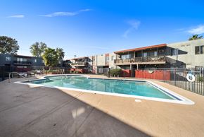 North Hills apartment for rent - A swimming pool surrounded by a fence and buildings.