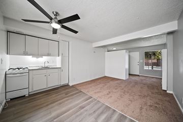 Van Nuys apartment for rent - A spacious living room with a kitchen area in the background.
