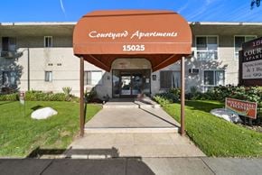 Van Nuys apartment for rent - The entrance to Courtyard Apartments with a red sign on the right.