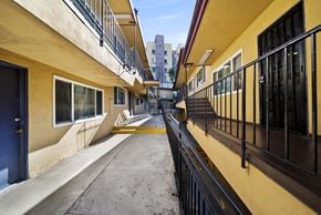 Los Angeles apartment for rent - A long, narrow balcony with black railings and a yellow wall.