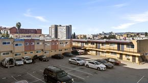 Los Angeles apartment for rent - A parking lot with cars and apartment buildings in the background.