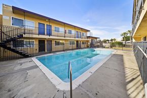 Los Angeles apartment for rent - A swimming pool is surrounded by a concrete floor and a black fence.