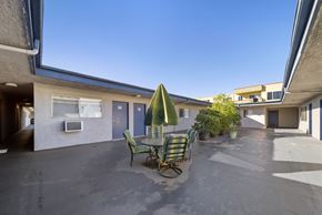 Van Nuys apartment for rent - A patio with a table and chairs under a green umbrella.