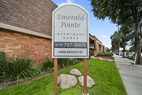 Van Nuys apartment for rent - A sign for Emerald Pointe Apartment Homes stands in front of a brick building.