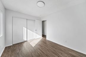 Los Angeles apartment for rent - A room with white walls and wooden flooring with a door and a window.