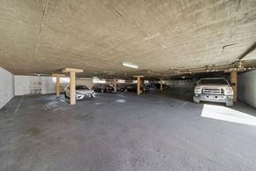 Los Angeles apartment for rent - A parking garage with a white car and a brown truck.