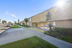 Buena Park apartment for rent - A sunny day at a commercial building with a palm tree in front.