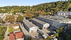Los Angeles apartment for rent - A large white building with a red roof is surrounded by other buildings and trees.