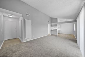 Hemet apartment for rent - A spacious room with a carpeted floor and white walls.