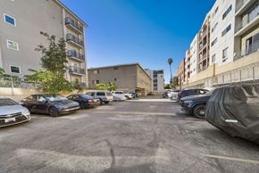 Hollywood apartment for rent - A parking lot with cars and buildings in the background.