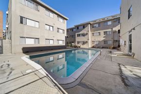 Hollywood apartment for rent - A swimming pool in a courtyard surrounded by buildings.
