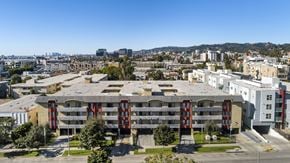 Hollywood apartment for rent - A large building with a red and white striped awning is in the foreground of a cityscape.
