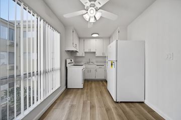 Hollywood apartment for rent - A kitchen with white appliances and cabinets is shown.