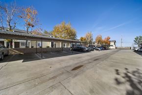 Palmdale apartment for rent - A parking lot with a building and trees in the background.