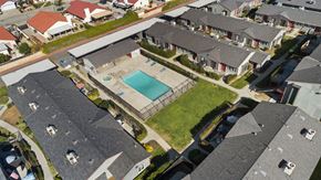 Hemet apartment for rent - A bird's eye view of a residential area with houses and a swimming pool.