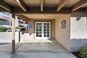 Perris apartment for rent - A building entrance with a blue sign on the wall.