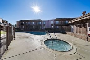 Perris apartment for rent - A sunny day at a pool with a building in the background.