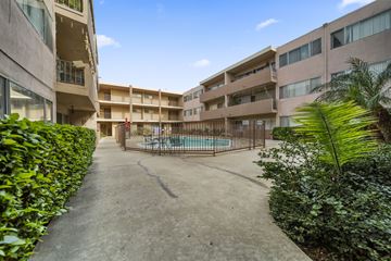 Panorama City apartment for rent - A courtyard with a pool surrounded by buildings and greenery.