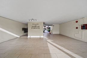 Panorama City apartment for rent - A sign that says "Welcome to North Pointe" hangs from the ceiling in a spacious room with tiled floors.
