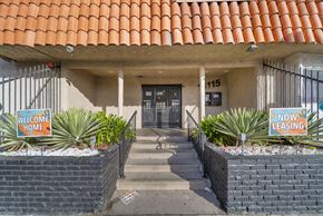 North Hills apartment for rent - A building with a red tile roof has a sign that says "Welcome Home" and "Now Leasing.".