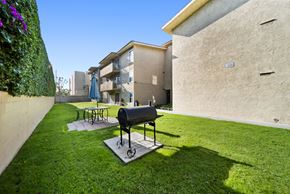 Panorama City apartment for rent - A black grill is on a stand in a grassy yard.
