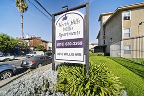 Panorama City apartment for rent - A sign for North Hills Willis Apartments is displayed in front of a building.