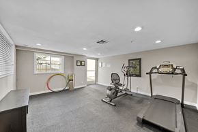 Los Angeles apartment for rent - A spacious room with a treadmill, exercise bike, and a chair.