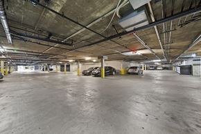 Los Angeles apartment for rent - A parking garage with concrete floors and yellow poles.