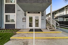 San Bernardino apartment for rent - A building with a leasing office entrance has a yellow line painted on the concrete.