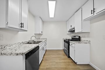 San Bernardino apartment for rent - A kitchen with white cabinets and a marble countertop.