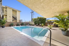 Van Nuys apartment for rent - A small pool in a backyard with a building in the background.