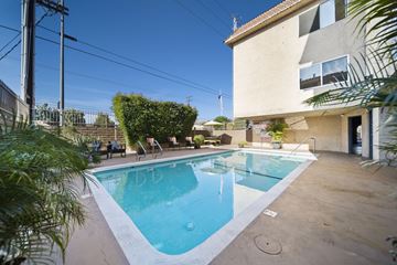 Van Nuys apartment for rent - A small pool in a backyard with a house in the background.