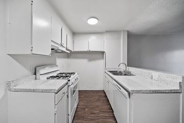 North Hollywood apartment for rent - A kitchen with white cabinets and a marble countertop.