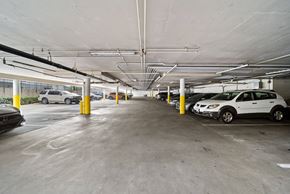 Long Beach apartment for rent - A parking garage with cars parked and yellow bollards.