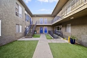North Hills apartment for rent - A courtyard with a staircase and a blue door.