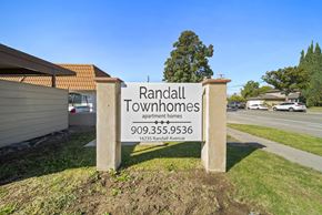 Fontana apartment for rent - A sign for Randall Townhomes stands in front of a building.