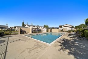 Fontana apartment for rent - A swimming pool surrounded by a concrete patio and lounge chairs.