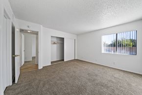 Perris apartment for rent - A room with a carpeted floor and a window with blinds.