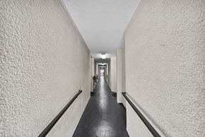 Los Angeles apartment for rent - A long hallway with white walls and a black floor.