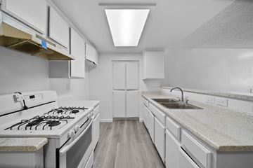 Los Angeles apartment for rent - A modern kitchen with white cabinets and a white gas stove.