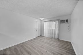 Los Angeles apartment for rent - A room with a wooden floor and a window with blinds.