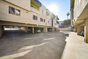 Los Angeles apartment for rent - A sunny day at a parking lot with cars and buildings.