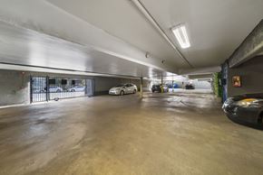 North Hollywood apartment for rent - A parking garage with a white car and a black car parked inside.