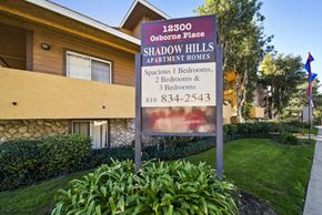 Pacoima apartment for rent - A sign for Shadow Hills Apartment Homes is in front of a building.